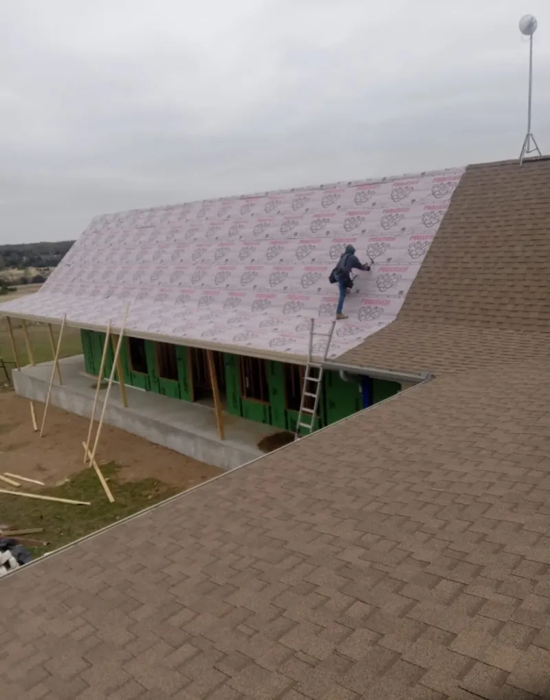 Worker preparing underlayment for a metal roof installation in Downers Grove